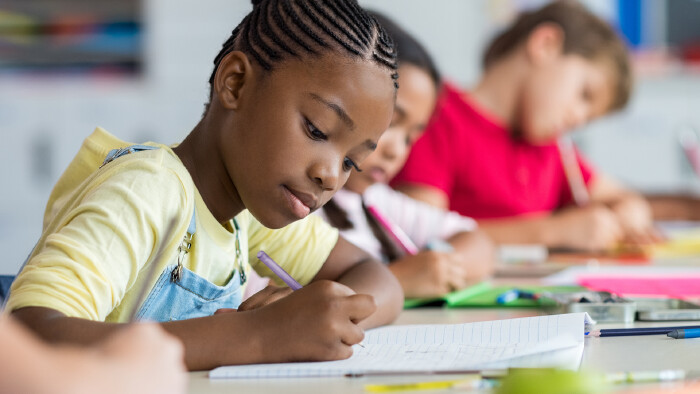 © Rido, stock.adobe.com Schulmädchen schreibt in der Klasse